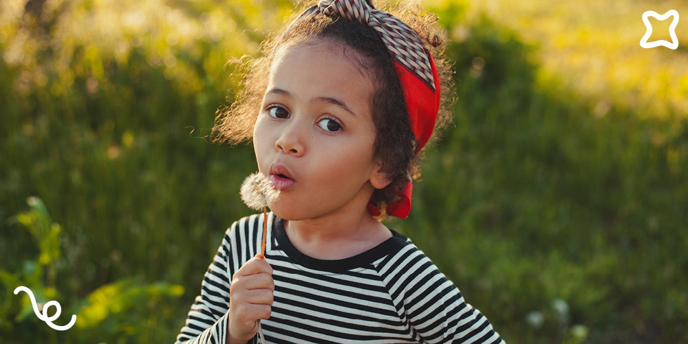 Child wearing a striped shirt and red headband outdoors