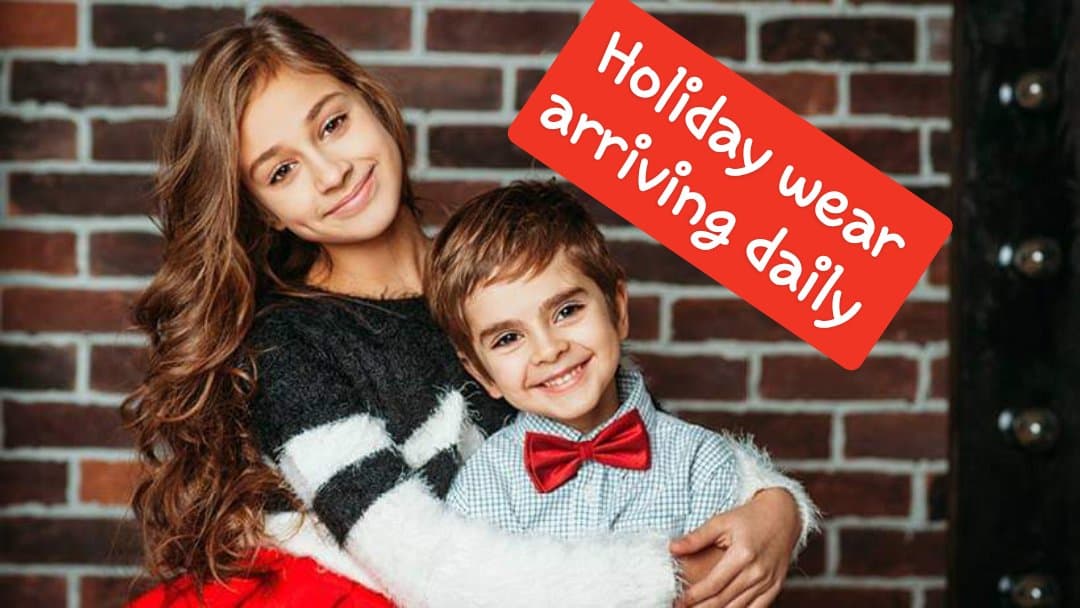 Holiday wear arriving daily. Two kids hugging in holiday apparel.