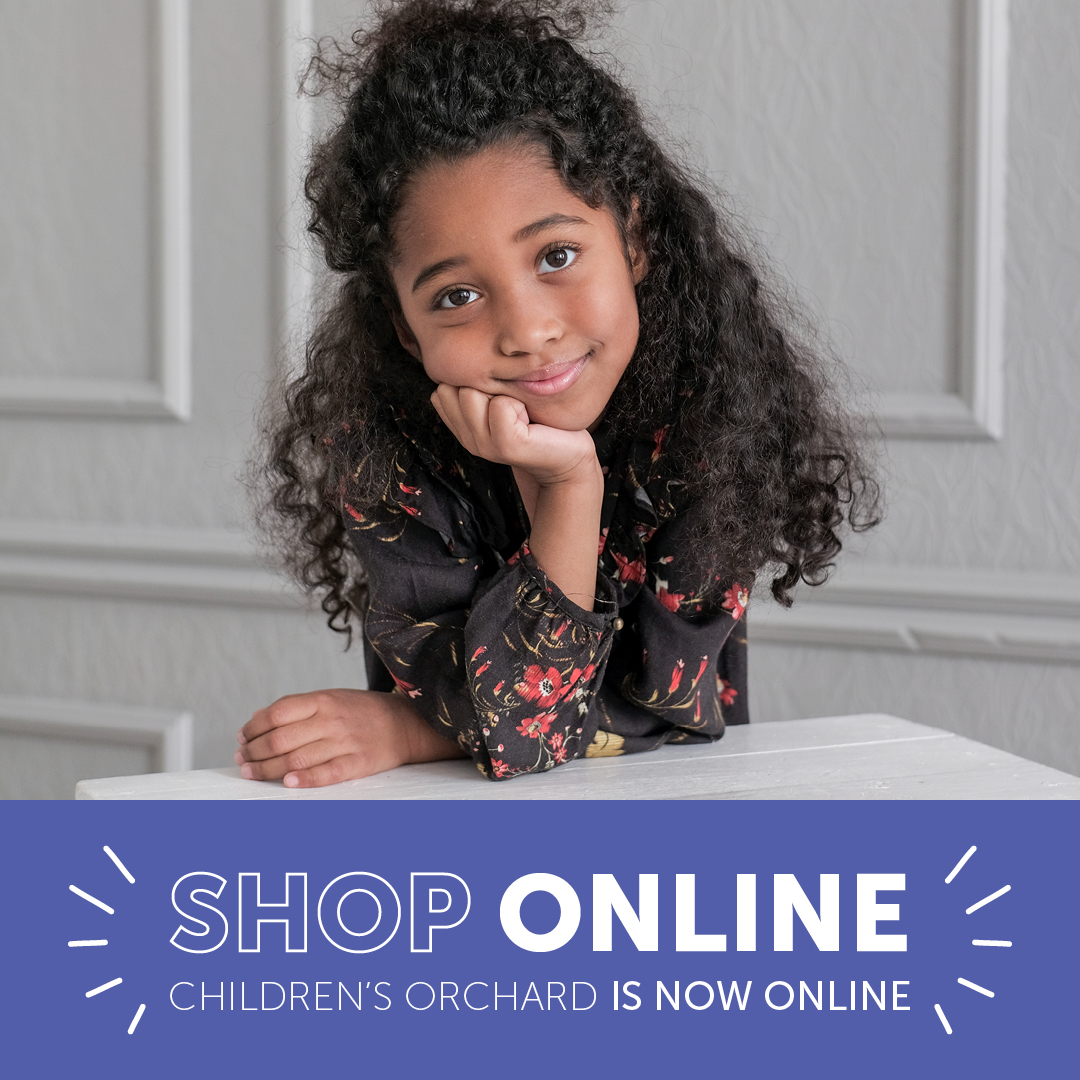 Shop online: Children's Orchard is now online. Little girl leaning on elbow wearing flower patterned shirt.